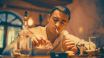 A young man in a dimly lit bar, looking fatigued as he smokes a cigarette and pours a shot of alcohol, symbolizing the long-term effects of bad habits that once felt beneficial.