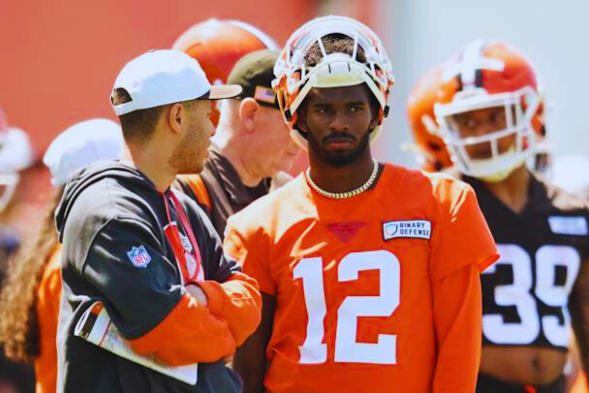 A side profile of Shedeur Sanders with his helmet off, deep in thought.