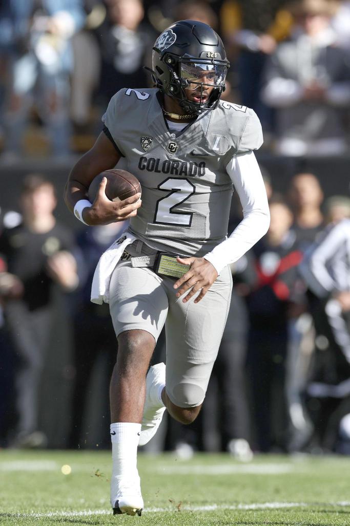 Shedeur Sanders running with the football in a Colorado Buffaloes uniform during a college football game.