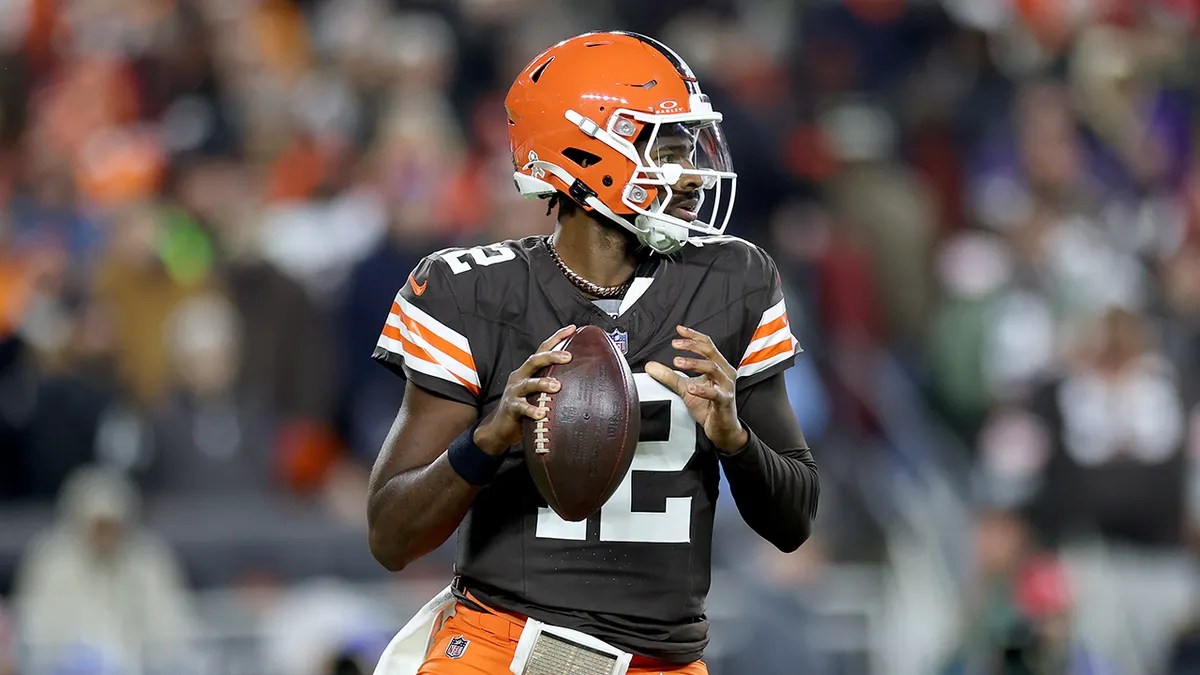 Shedeur Sanders in a Cleveland Browns uniform holding the football in the pocket during an NFL game.