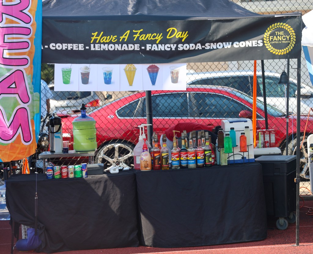 The Fancy Coffee & Treats vendor booth offers coffee, lemonade, fancy sodas, and snow cones during the Change for De'Quan community event in Denver.