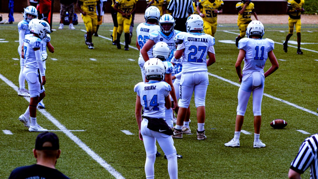 Riverdale Ravens 13U football players regroup on the field during their game against the Colorado Lions at Montbello Rec Center in Denver.