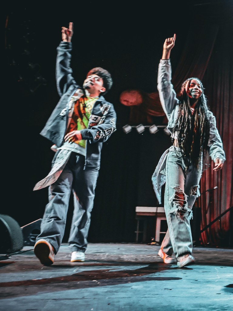 Two Denver artists performing together onstage during a live local hip-hop show in Denver, Colorado.